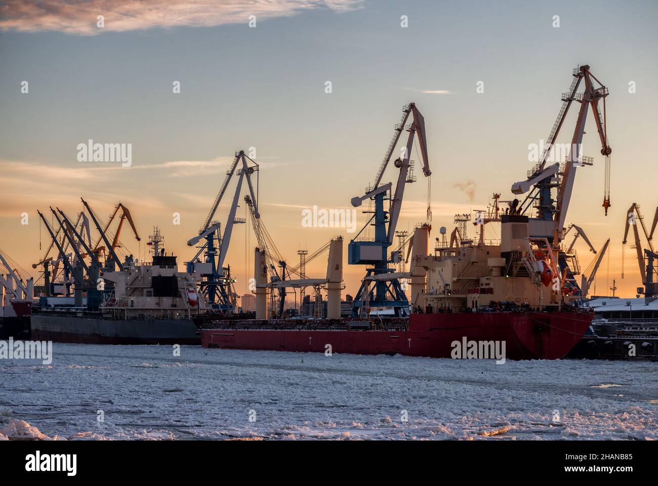 Sea cargo port in winter. Dry cargo vessels at the berth with harbor cranes Stock Photo