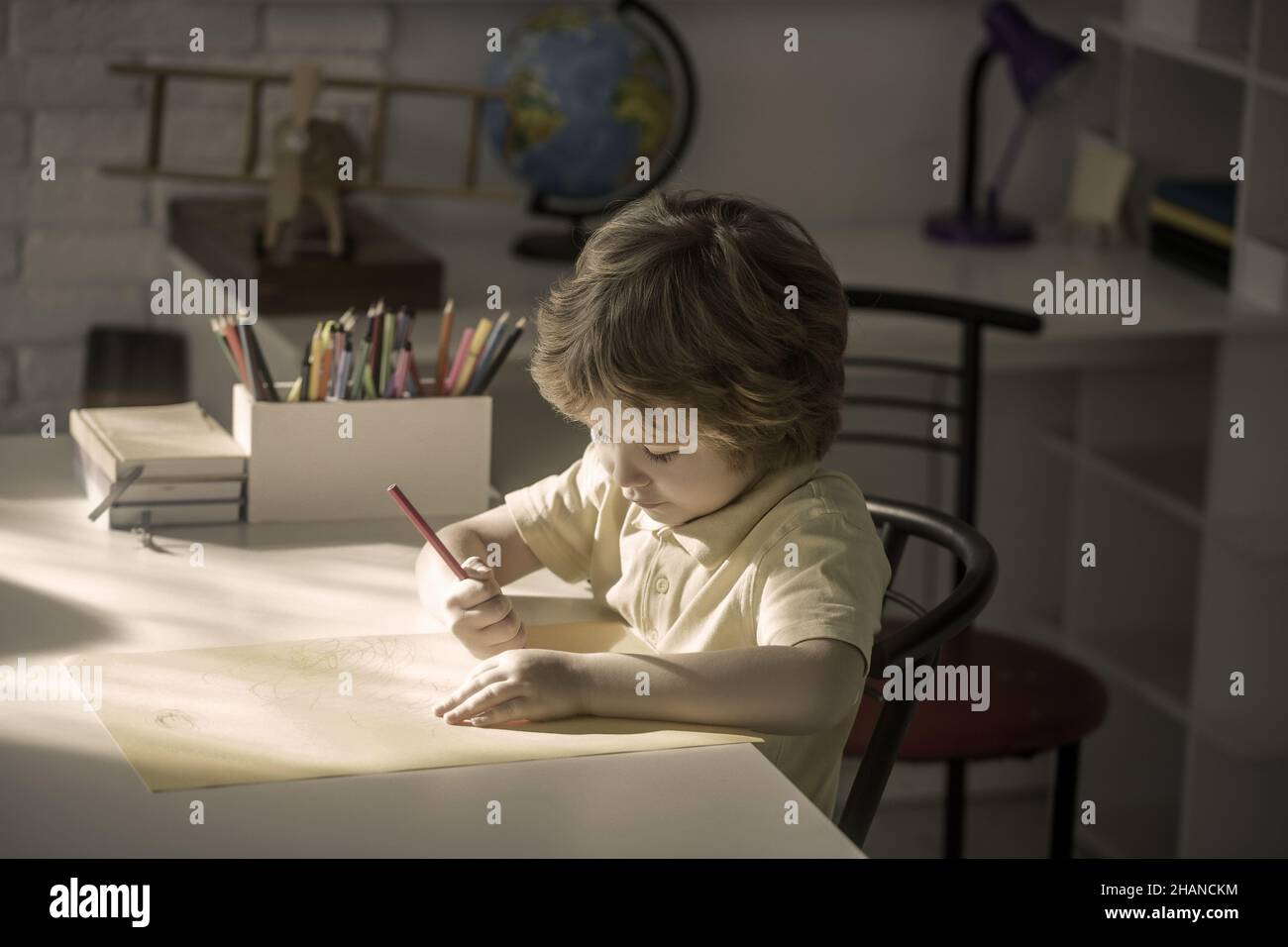 Little boy drawing in room, education and daycare. Stock Photo