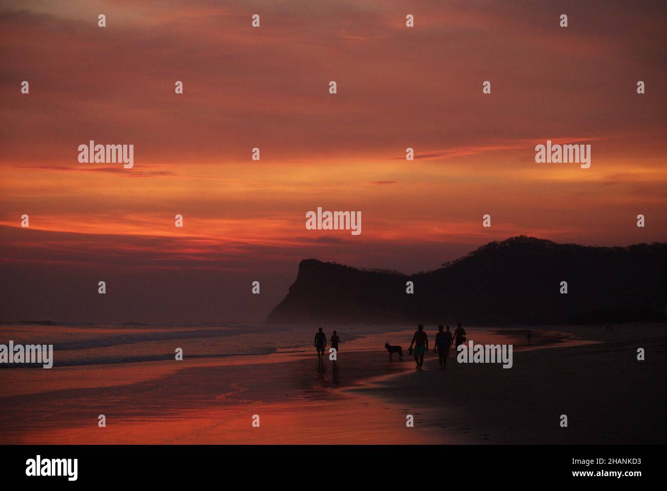 Silhouettes on the beach during a scenic sunset Stock Photo - Alamy