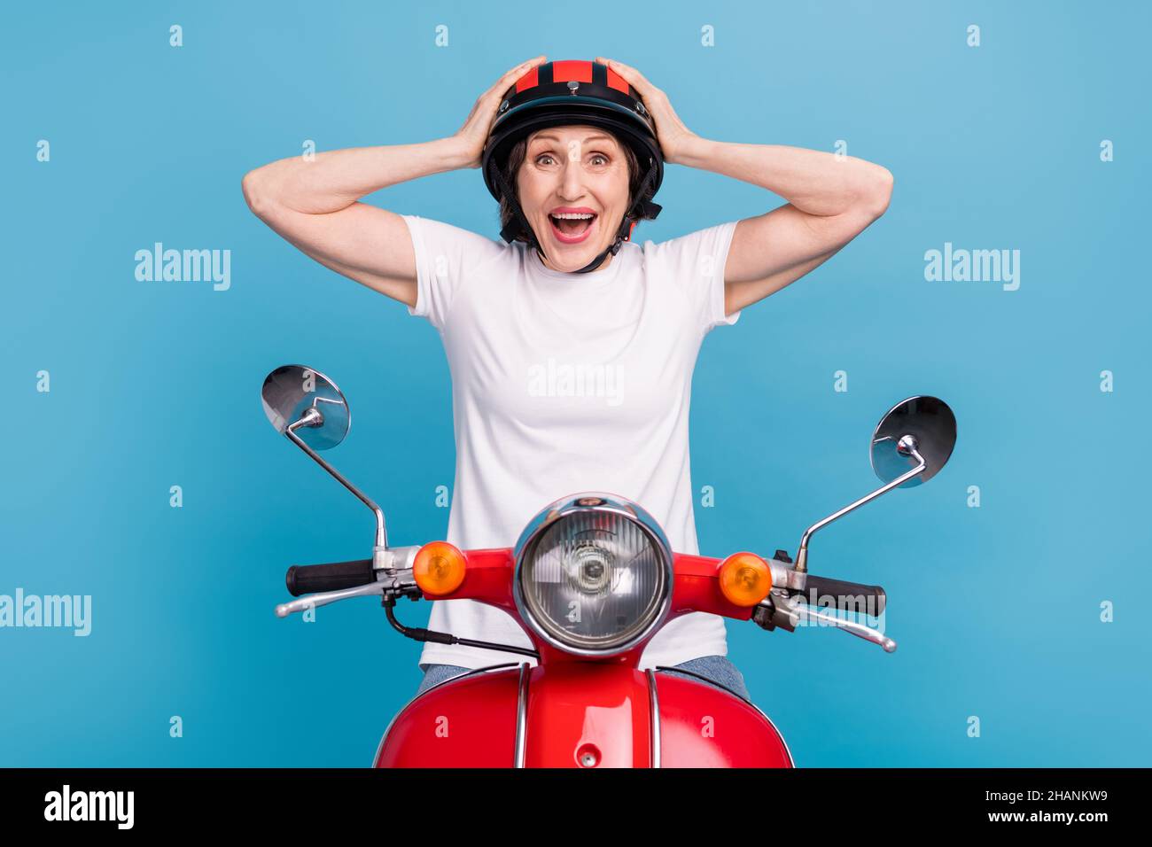 Portrait of attractive amazed cheerful woman riding moped sale reaction isolated over bright blue color background Stock Photo