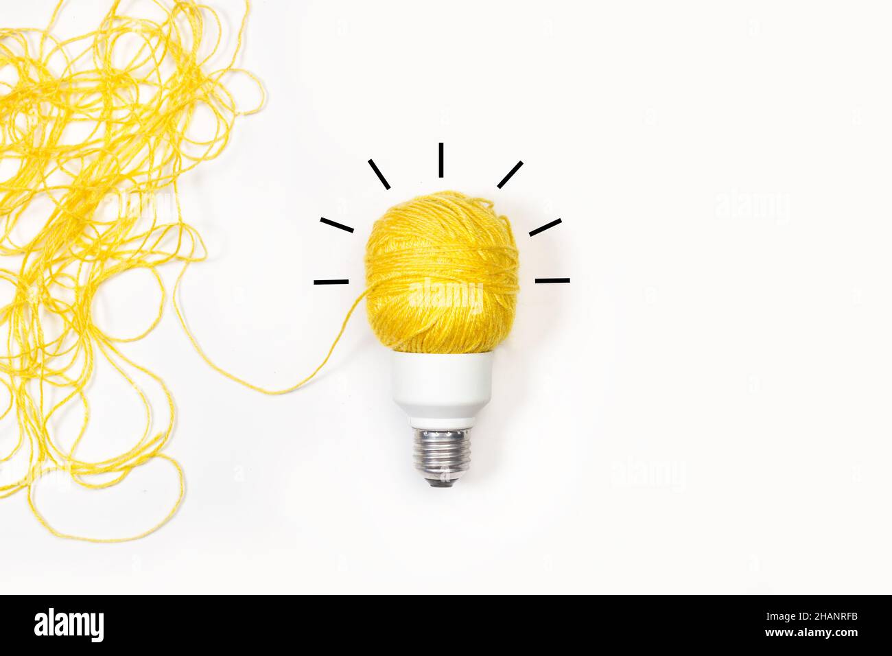 Light bulb made with a yellow thread on a white background Stock Photo -  Alamy