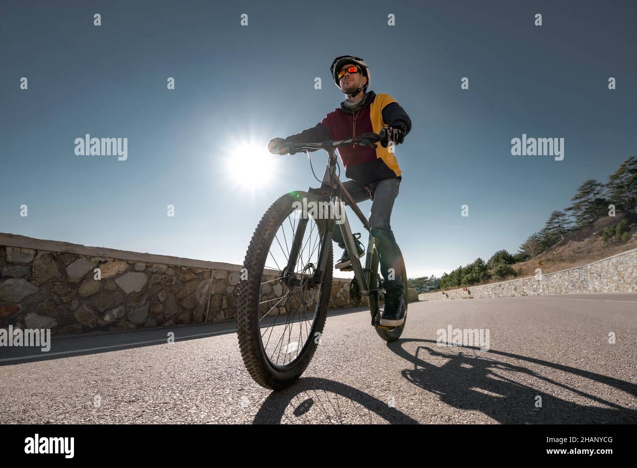 Man cyclist rides mountain bike on open road. Concept of active sport or fitness Stock Photo