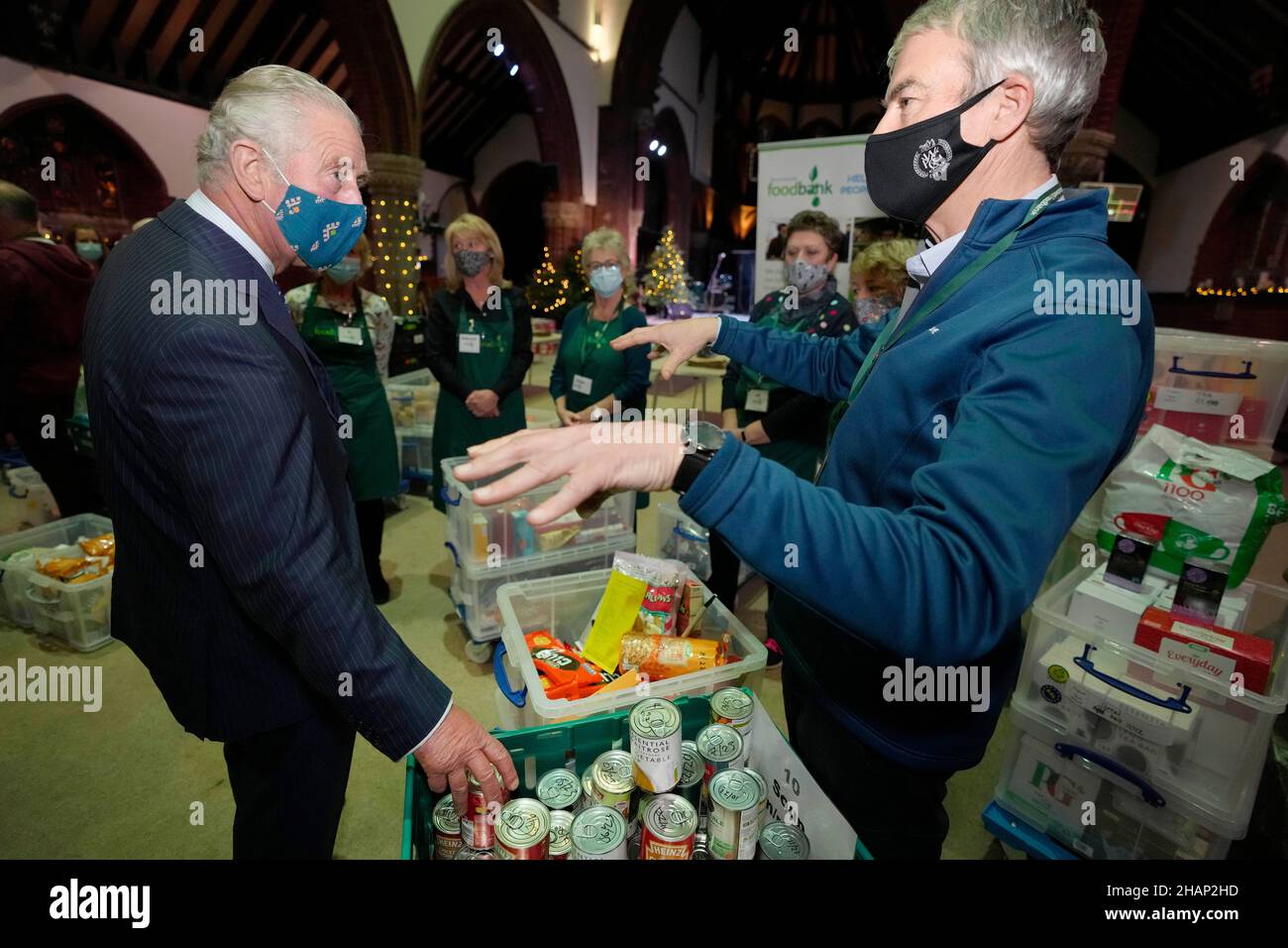 The Prince of Wales (left) speaks to a volunteer during a visit to Wandsworth Foodbank at St. Mark's Church in Battersea Rise, London. Picture date: Tuesday December 14, 2021. Stock Photo
