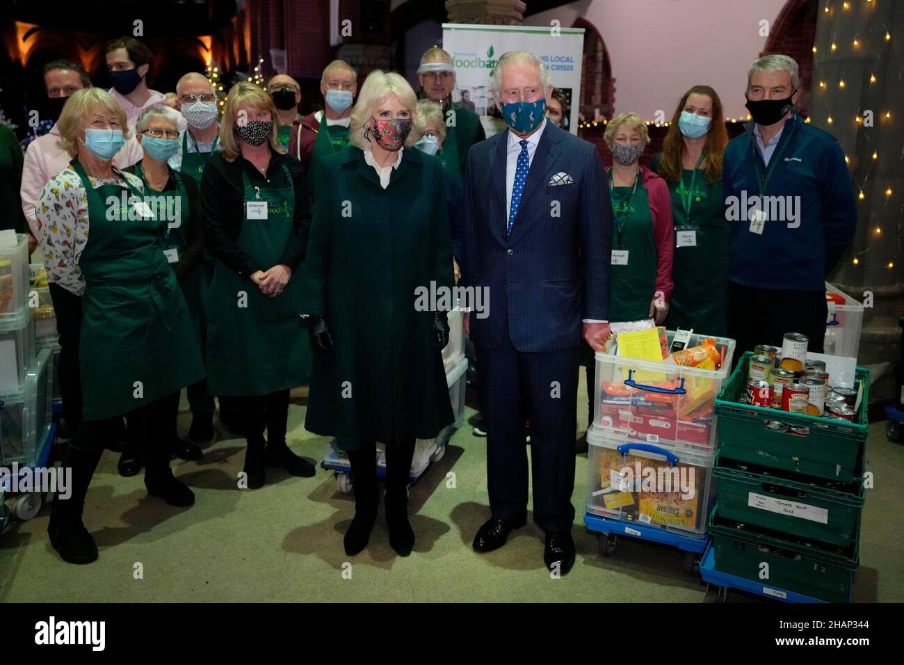 The Prince of Wales and Duchess of Cornwall with volunteers during a visit to Wandsworth Foodbank at St. Mark's Church in Battersea Rise, London. Picture date: Tuesday December 14, 2021. Stock Photo
