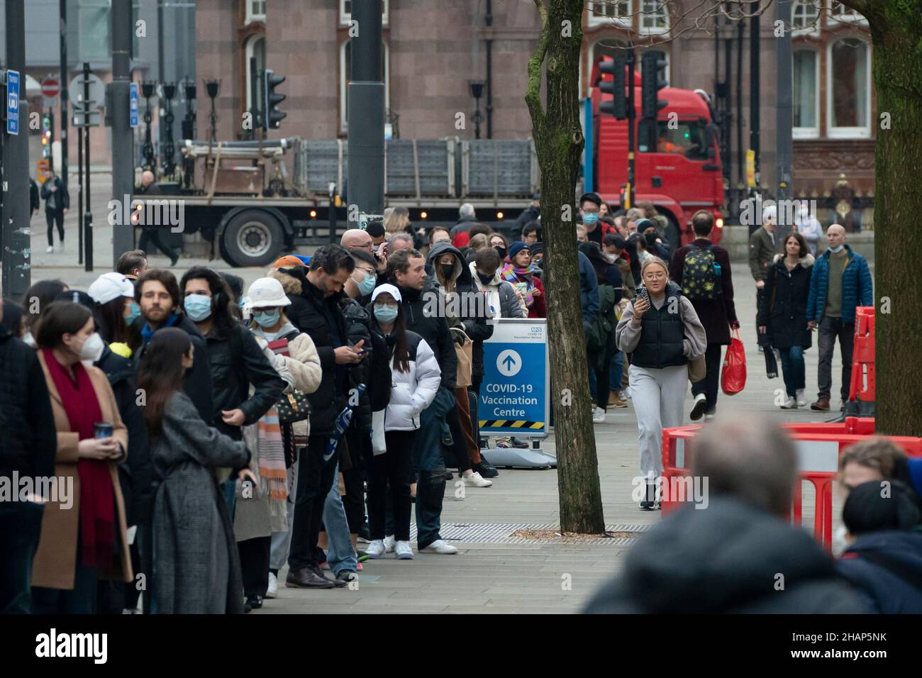 Manchester, UK, 14th December 2021. Members of thr public queue at a vaccination centre in central Manchester as fears grow that the Omicron variant will force the government into closing parts of the economy. Credit: Jon Super/Alamy Live News. Stock Photo