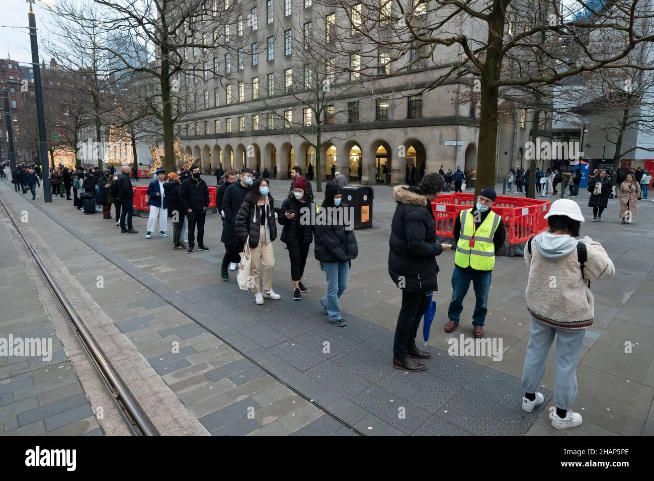 Manchester, UK, 14th December 2021. Members of thr public queue at a vaccination centre in central Manchester as fears grow that the Omicron variant will force the government into closing parts of the economy. Credit: Jon Super/Alamy Live News. Stock Photo