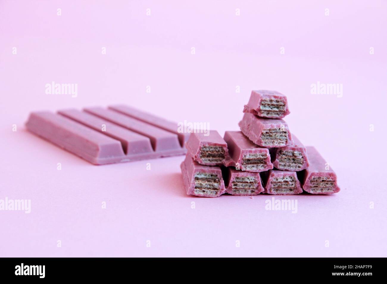 Ruby chocolate covered wafers sliced on pastel pink ground with copy space Stock Photo
