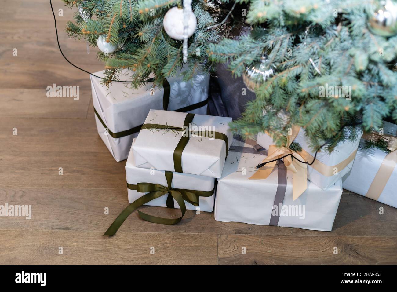 Beautiful Christmas gift boxes on floor near fir tree in room Stock ...