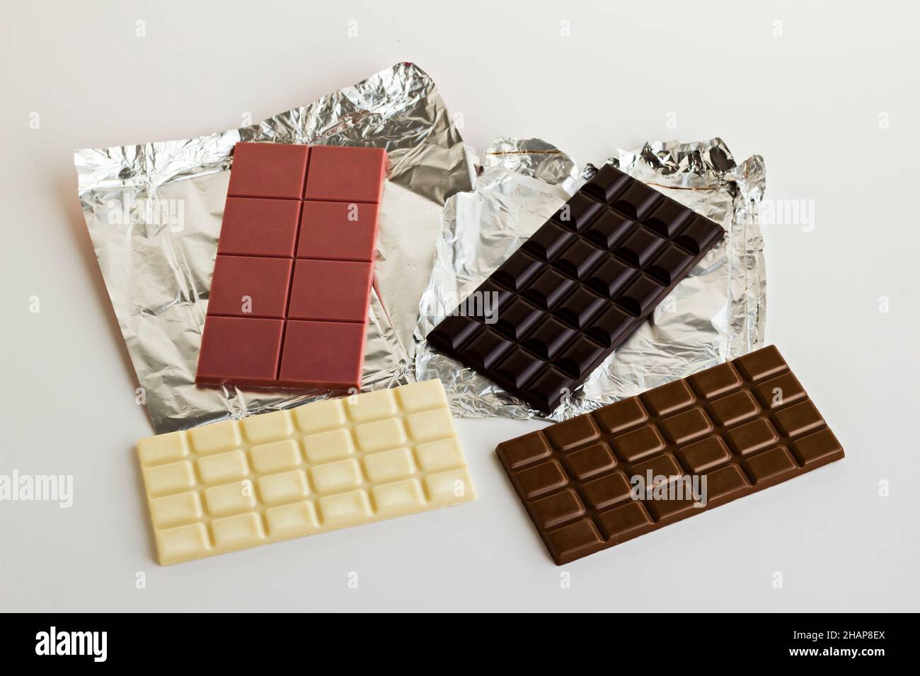 Fourth type in chocolate: Ruby on the aluminum own packaging with bitter,milky and white chocolate.Above view. Stock Photo