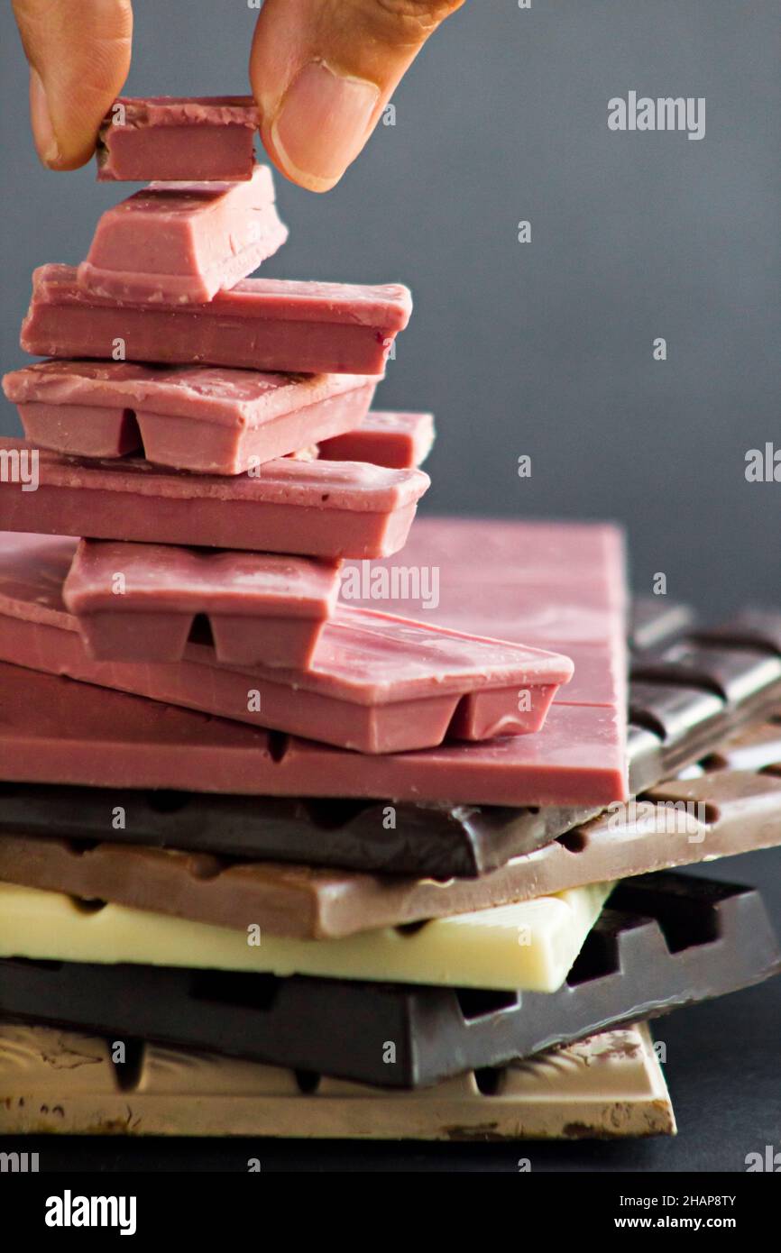 Fourth type in chocolate;Ruby,Hand is putting last piece of chocolate on stack. Stock Photo