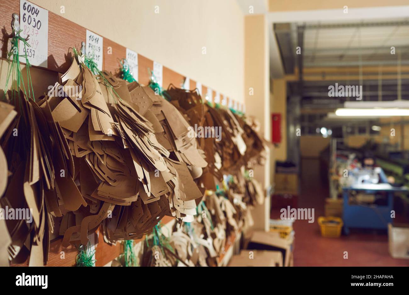 Lots of sewing patterns for shoe details hanging on peg rack at