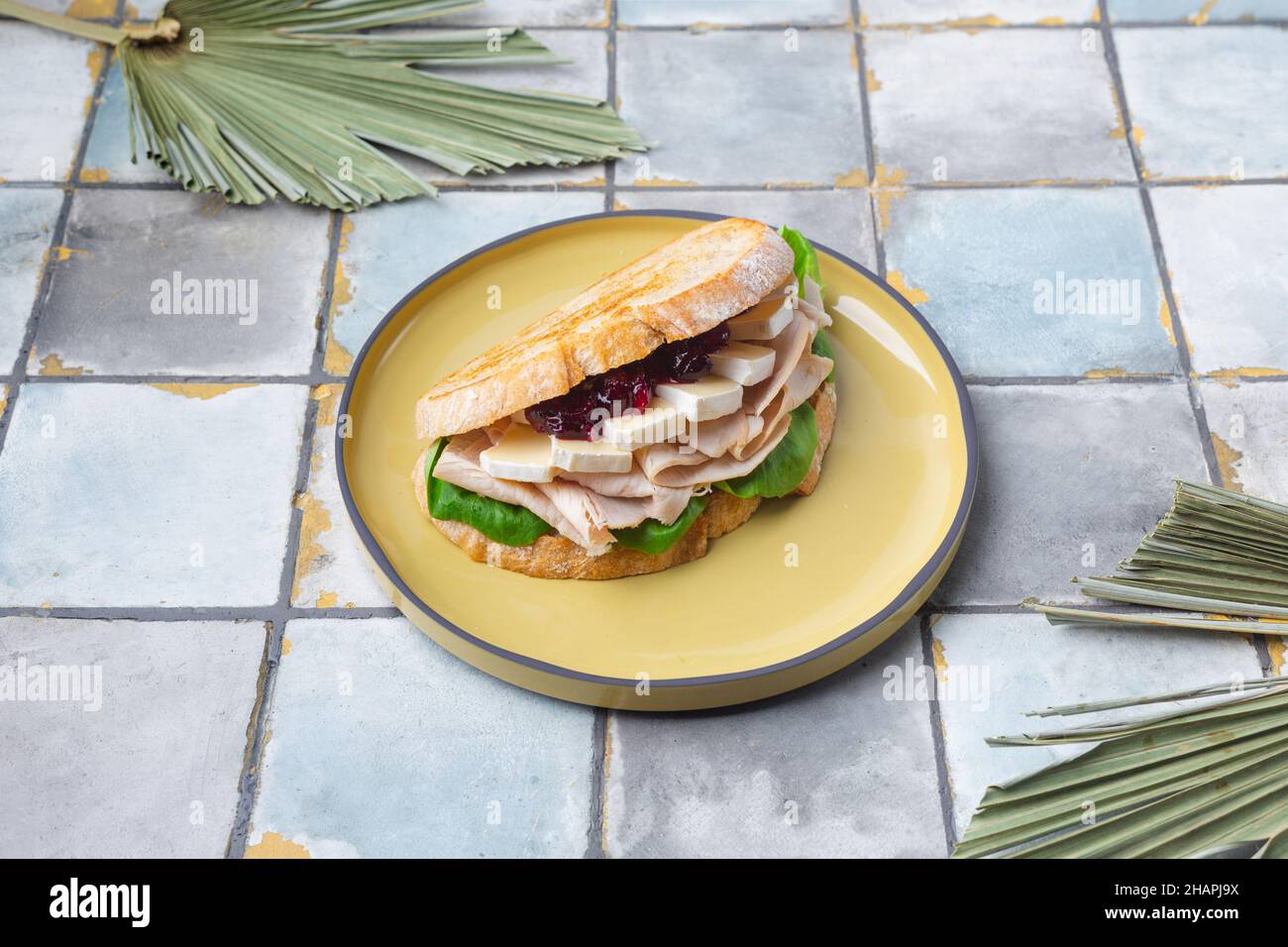 toast with spinach, French cheese Bri ham and jam on tile background Stock Photo