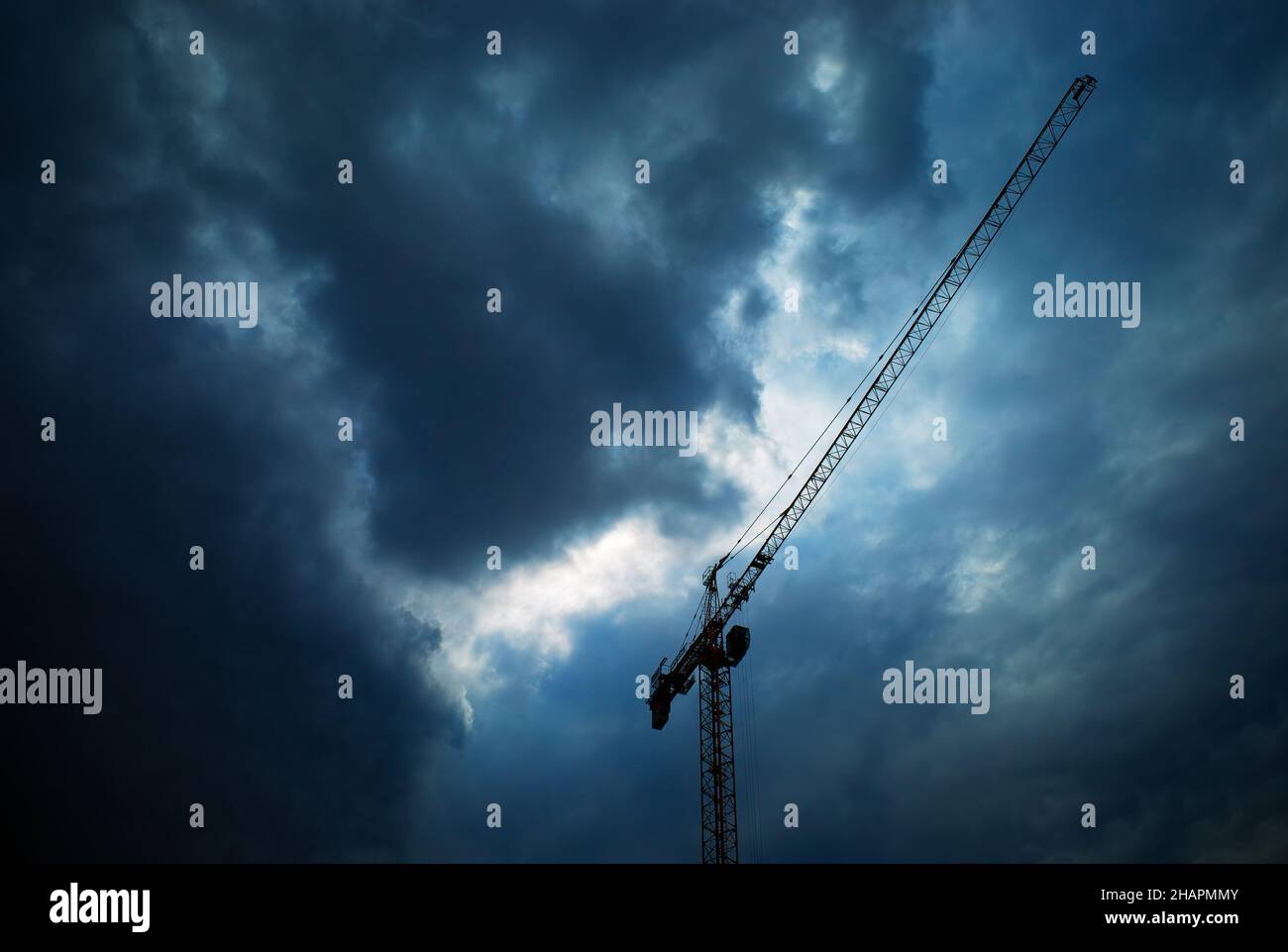 Overcasted Construction crane under overcasted clouds Stock Photo - Alamy