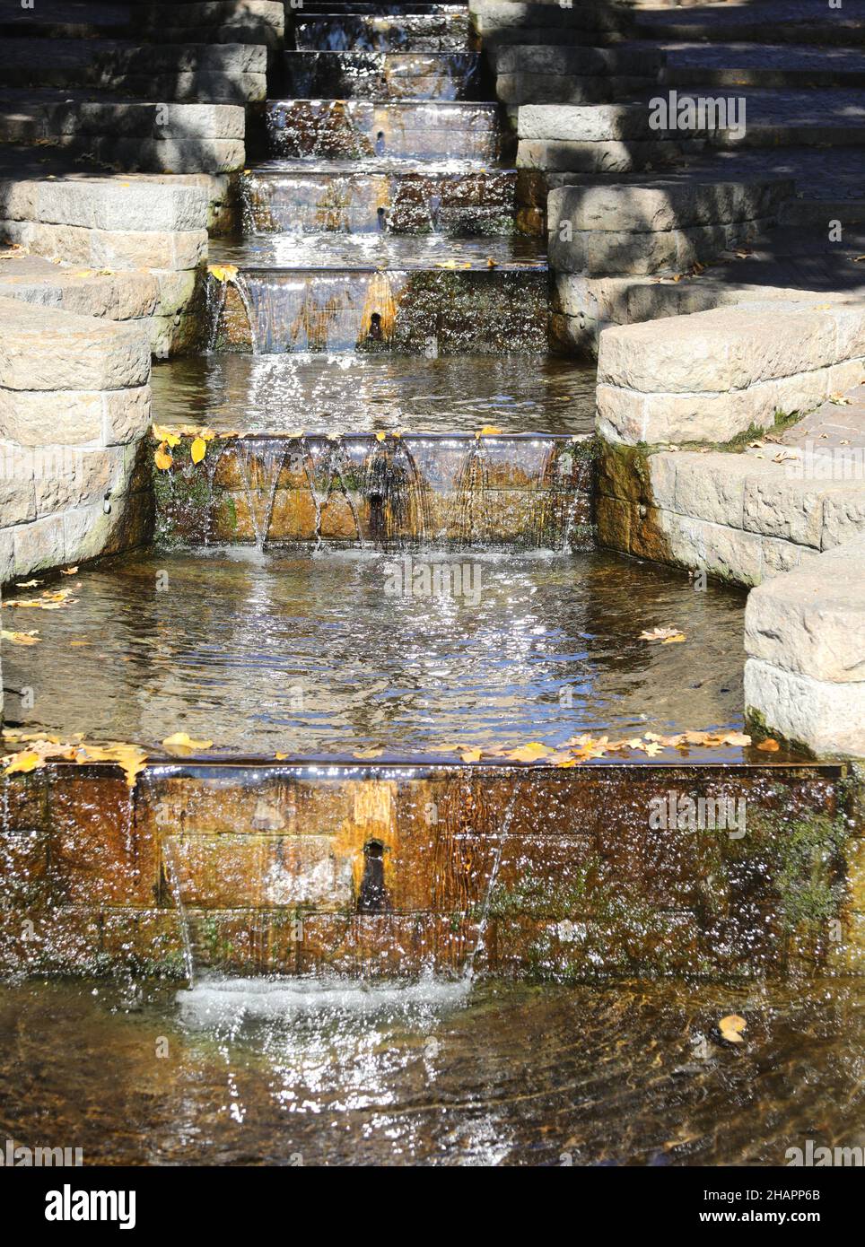 small artificial waterfall made on the stone steps Stock Photo