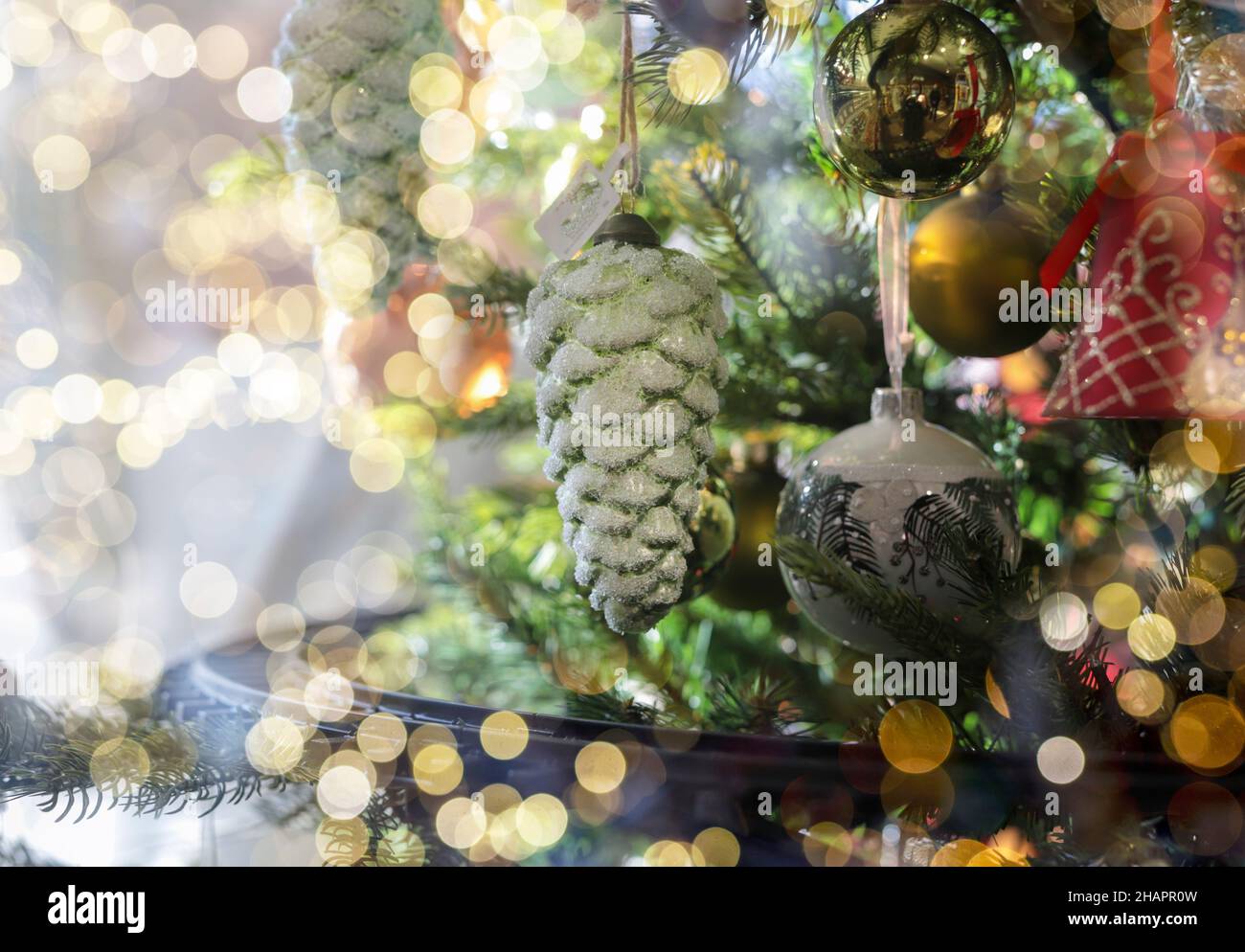 Cone toy hanging on Christmas fir tree close up. Xmas ornament on firtree. Stock Photo