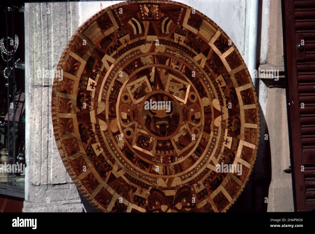 Merida, Yucatan, Mexico. 12/30/1985. Aztec Sunstone calendar.  Crafted in mosaic wood.  Original stone calendar carved in basalt on display at the NATIONAL ANTHROPOLOGY MUSEUM in Mexico City.  Original stone calendar carved circa 1502-1520 AD. Stock Photo