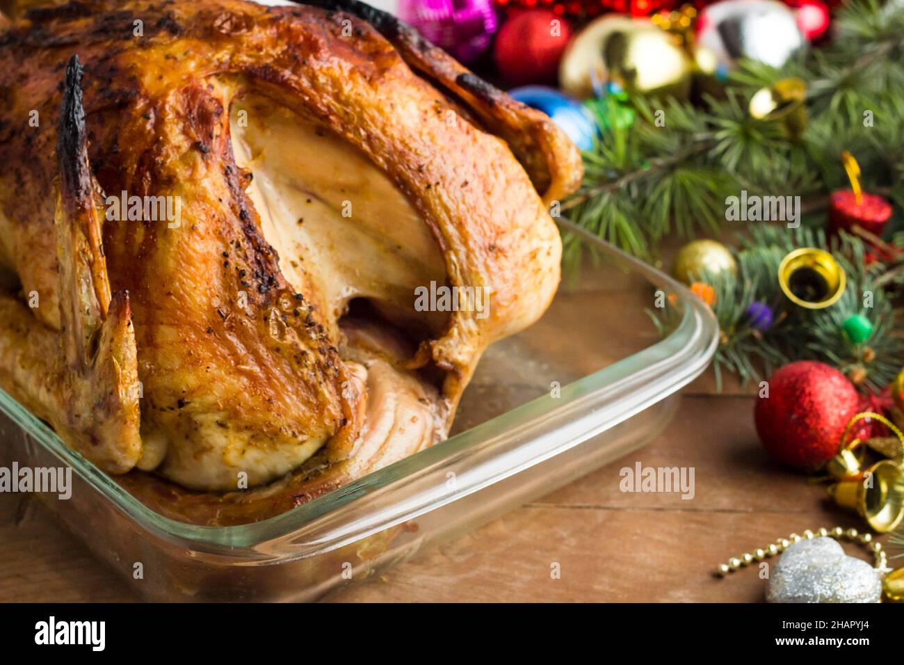 Christmas turkey marinated in sauces, roasted in oven with a glass baking container on table