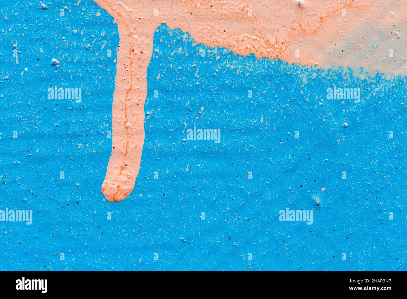 Macro close-up of a wall spray painted with light blue & sandy tan color. Spray paint splashes&drip. Abstract textured splattered graffiti background. Stock Photo
