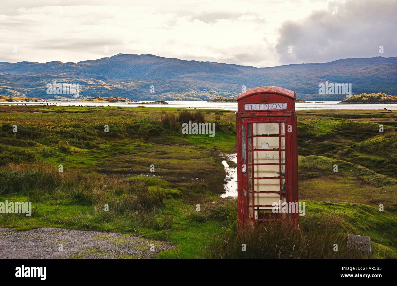 A red telephone box on the wetlands of Kentra Bay setup to serve the tiny coastal hamlets of Ardtoe on the Ardnamurchan peninsula, Scotland Stock Photo