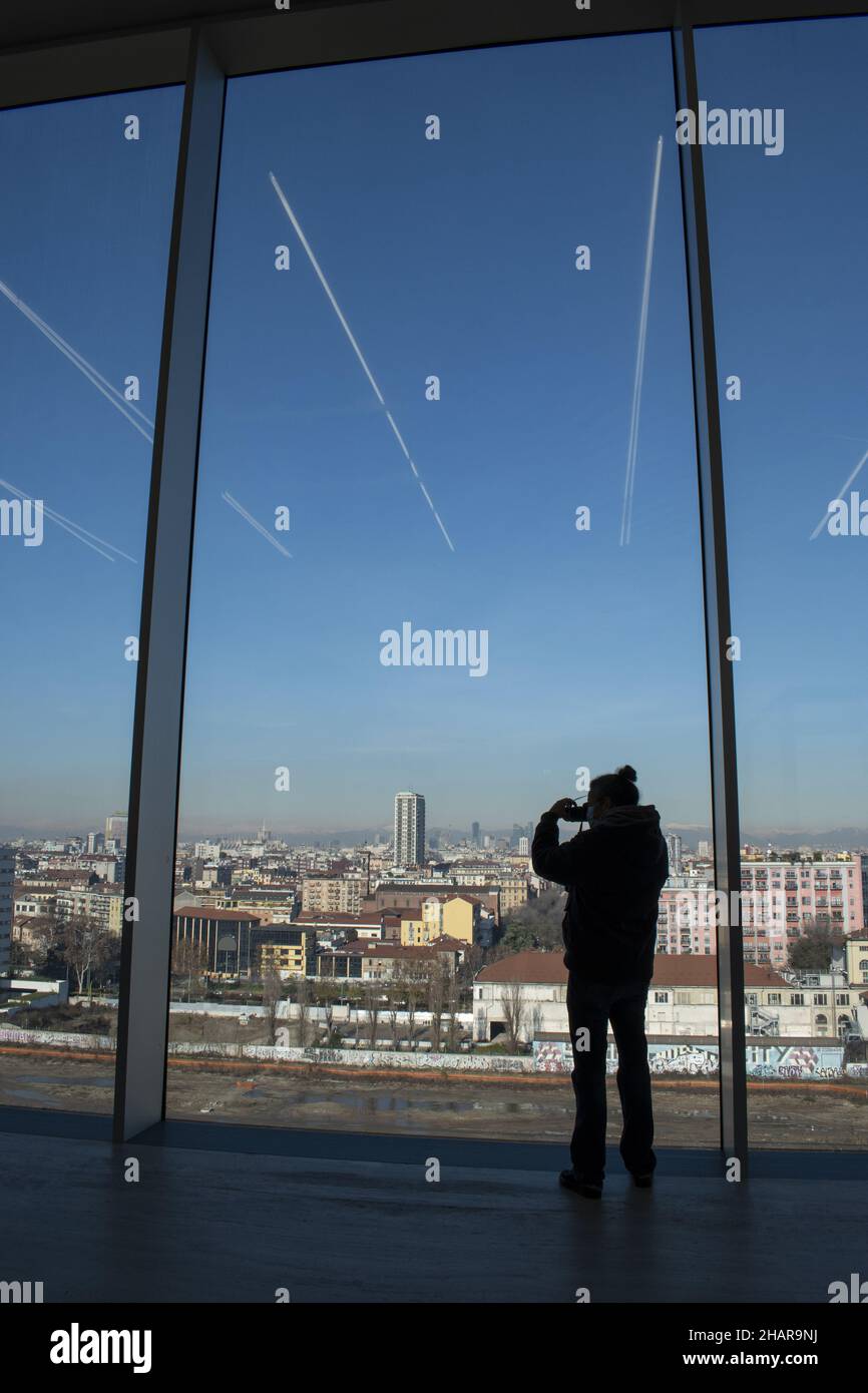 Milan, Italy: a man in front of the windows on the city skyline from the Tower of Fondazione Prada, building 60 meters high designed by Rem Koolhaas Stock Photo