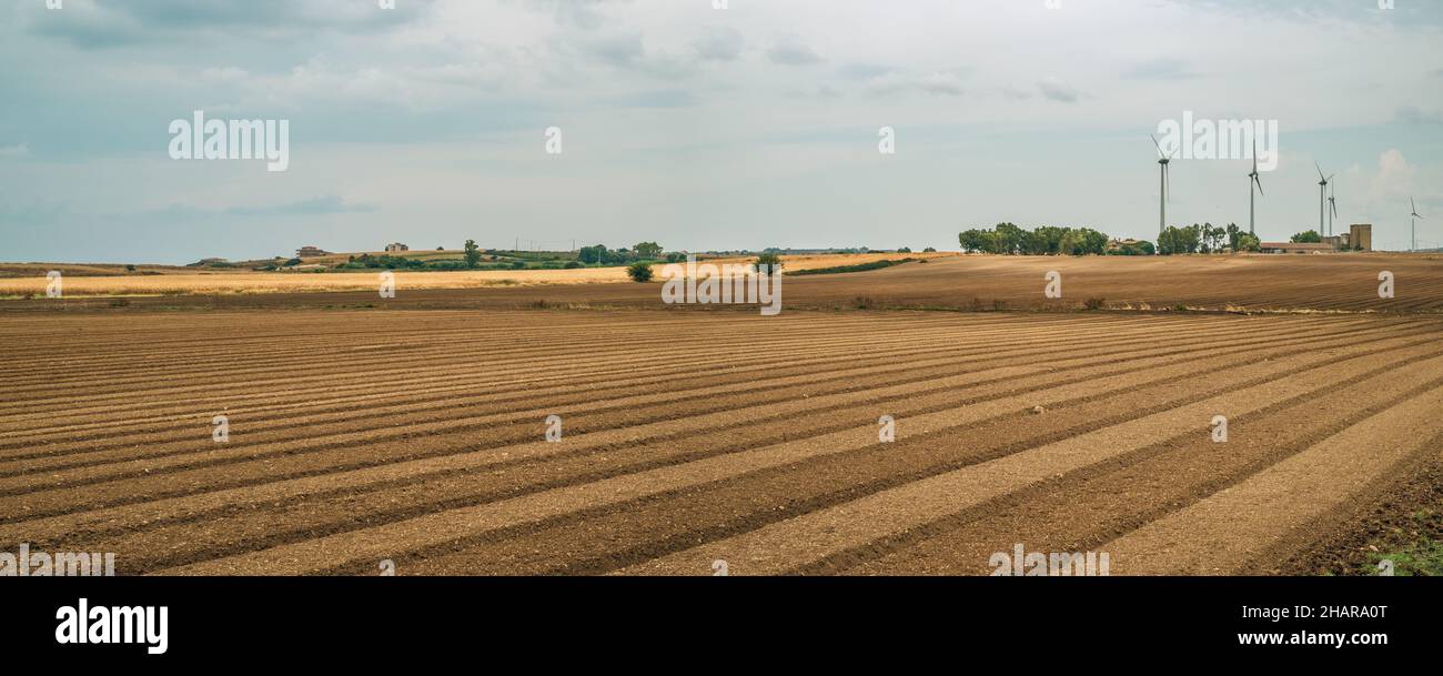 Farmland and wind farm in a September clody day in Crotone province, Calabria, Italy Stock Photo
