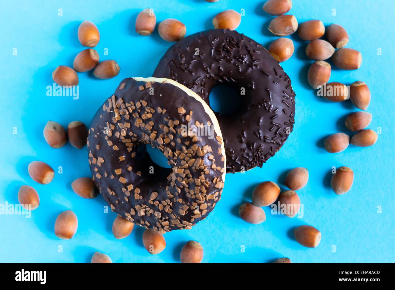 Donut with hazelnuts on a blue background, close up Stock Photo