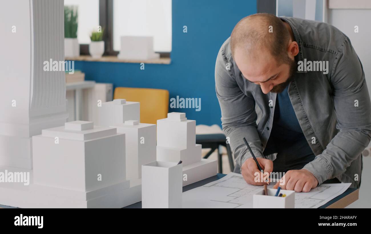 Close up of architect taking notes on blueprints plan to work on ...