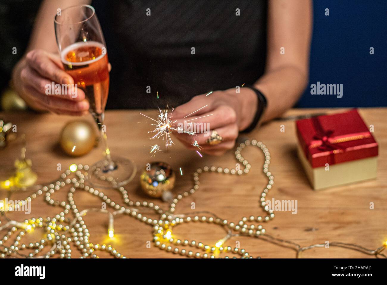 Champagne in hand against the background of the Christmas tree. Happy New year 2022. Stock Photo