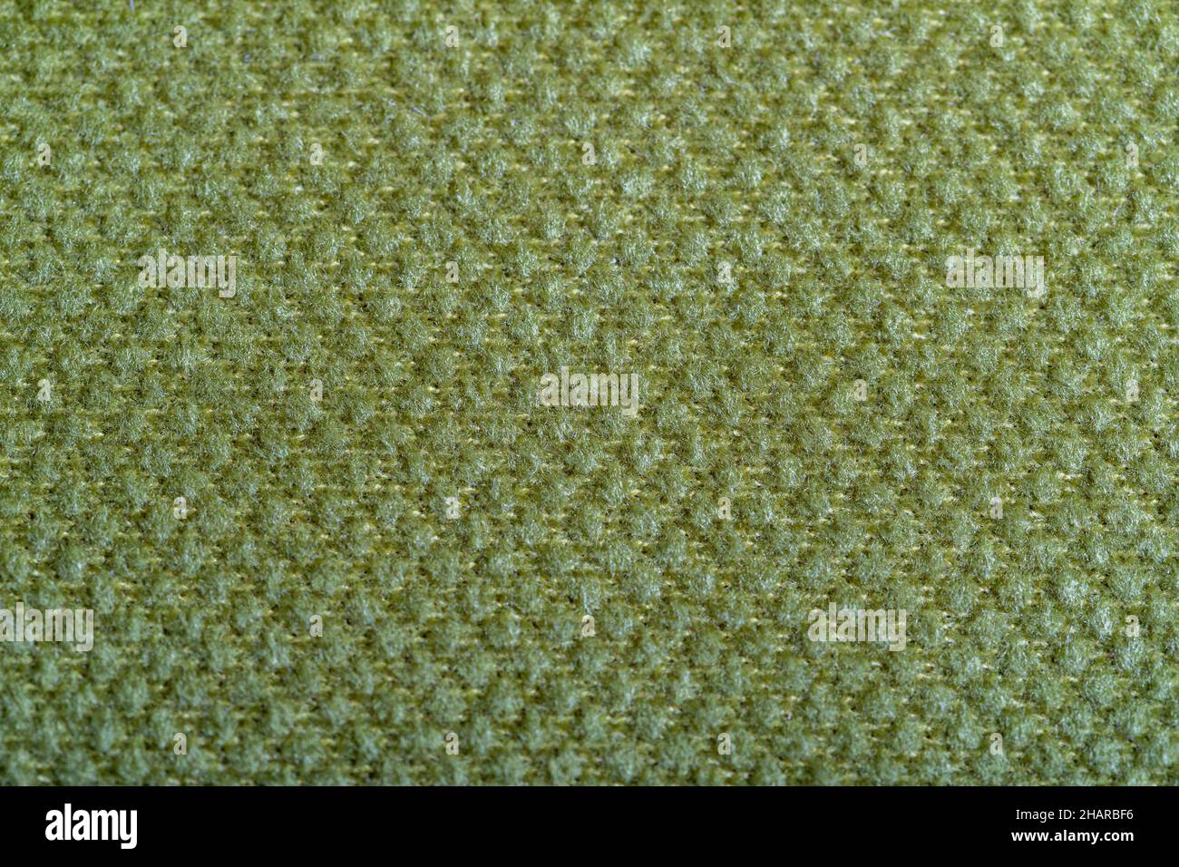 Green fabric texture. Furniture upholstery textiles. Embossed pattern. Woven fibers. The material is soft touch. Minimalism concept. High detail macro Stock Photo