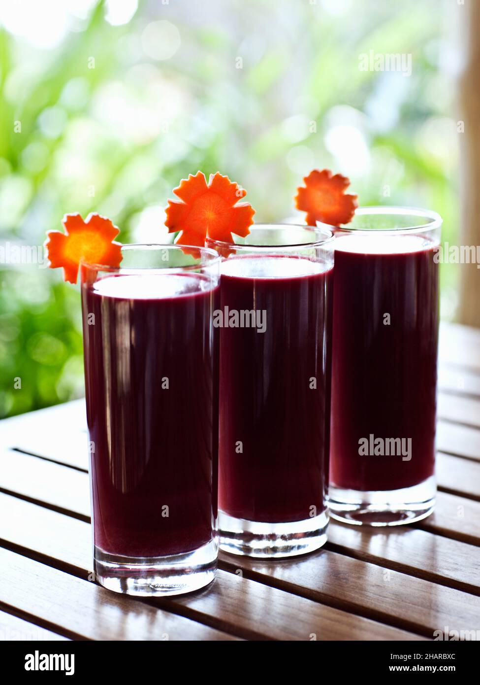 Trio of detox Juices at Kamalaya, Koh Samui, Thailand. A row of Red Zinger detox drinks are made of blended beet, cucumber, carrot and ginger juice. Stock Photo