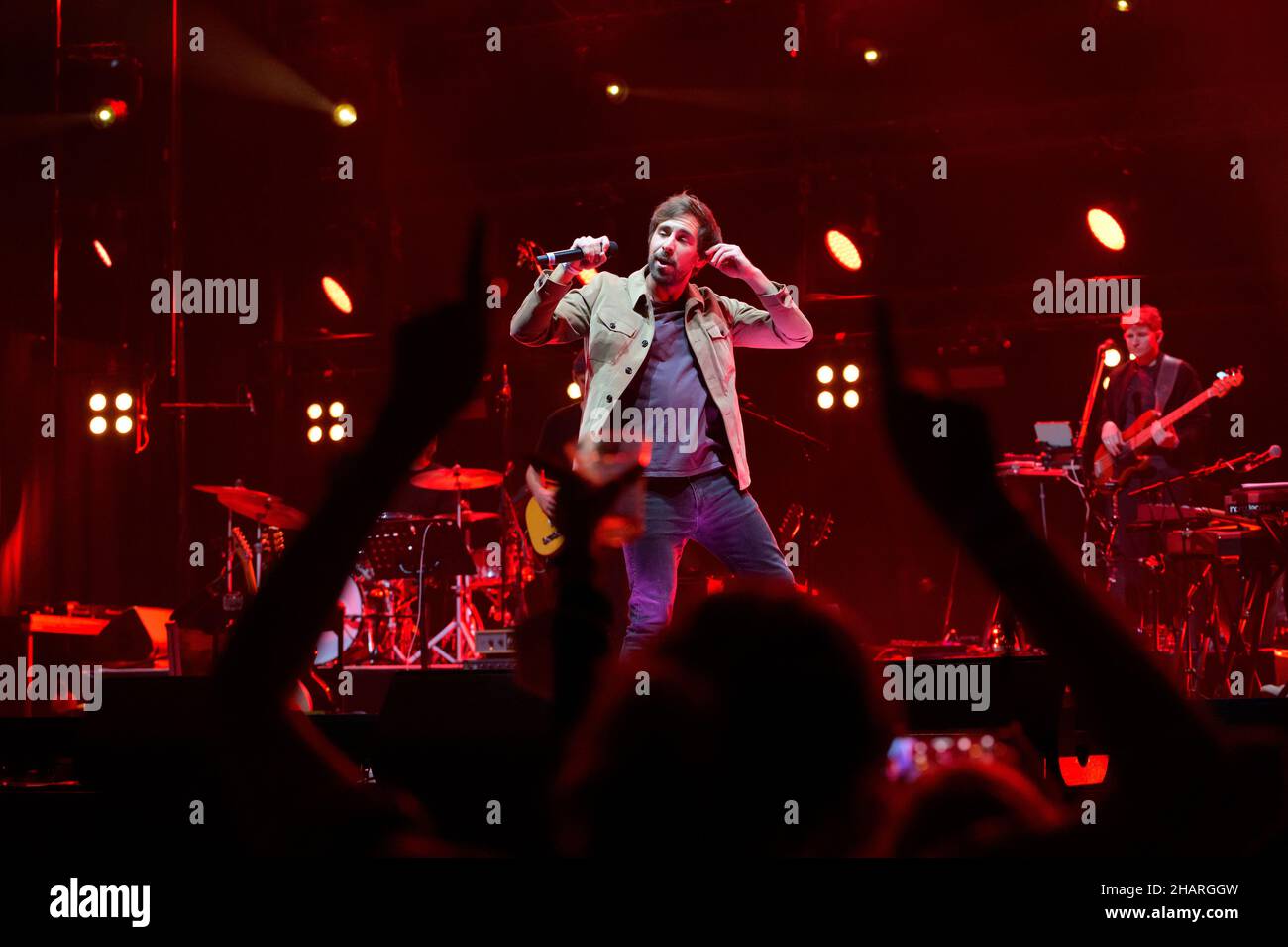 Hamburg, Germany. 14th Dec, 2021. Singer Max Giesinger sings in front of dancing fans on stage. Numerous well-known musicians and up-and-coming artists rocked the stage of Hamburg's Barclays Arena - but most of their audience was not sitting in the stands, but in front of the screens. The donation streaming concert of the 'AllHandsOnDeck' project was intended to raise as much money as possible for the benefit of concert staff and artists whose livelihoods are at risk. Credit: Jonas Walzberg/dpa/Alamy Live News Stock Photo