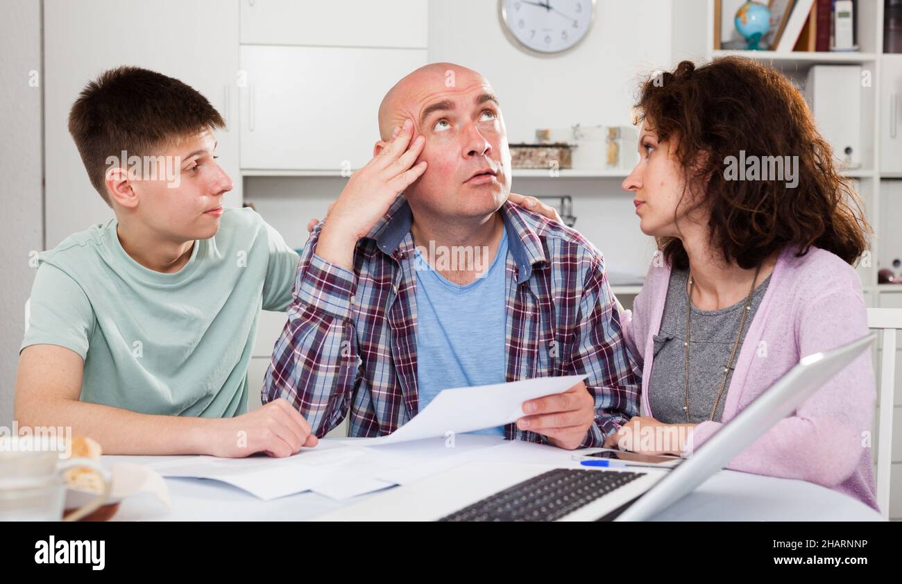 Family soothing chagrined man Stock Photo - Alamy