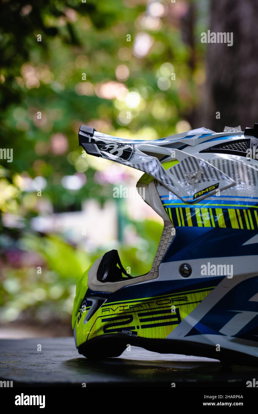 PHNOM PENH, CAMBODIA - Nov 02, 2021: A vertical shot of a yellow and blue Airoh aviator 2.3 motocross helmet on a table outdoors Stock Photo