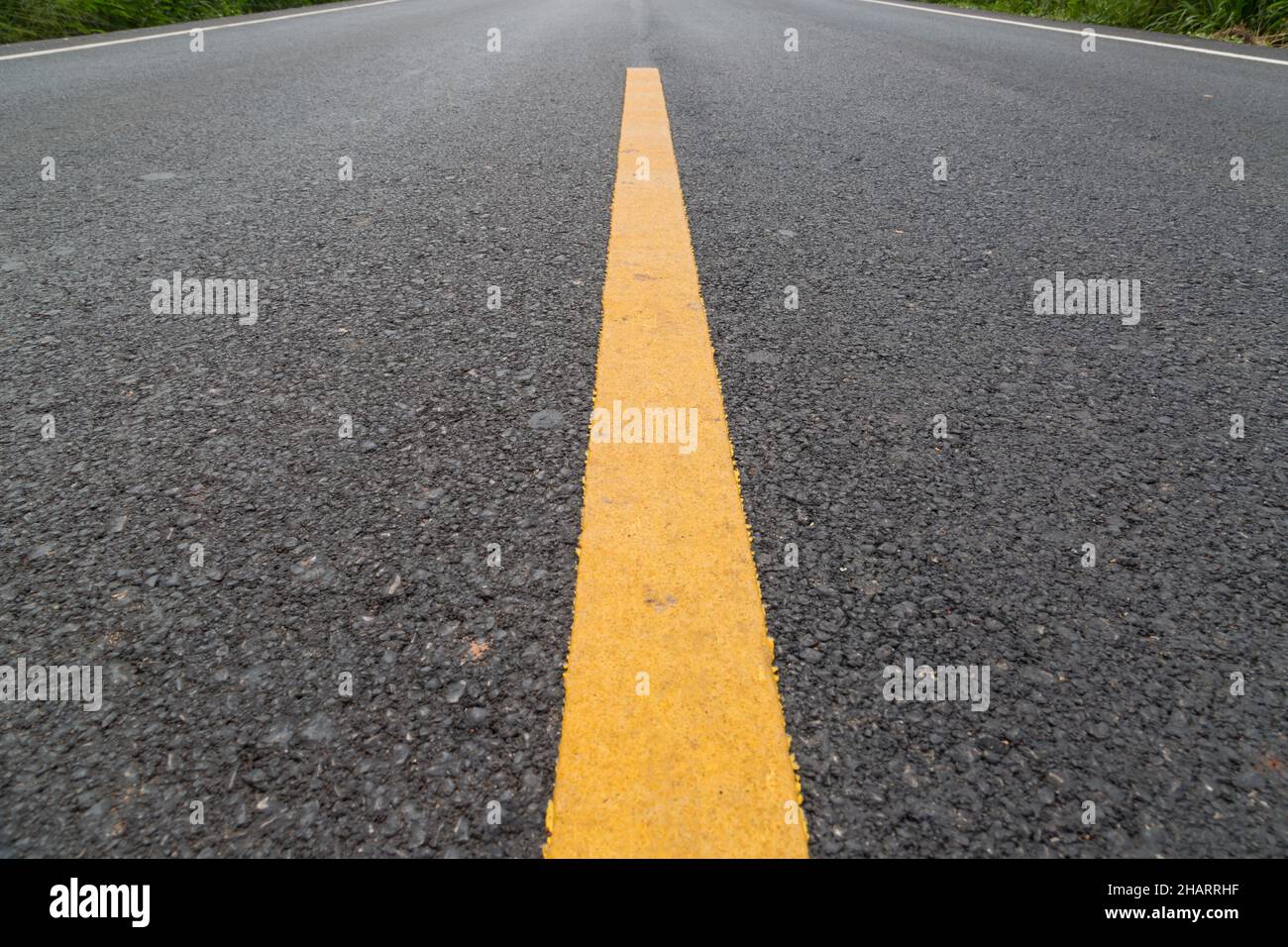 The yellow line on the road with tree and sky background Stock Photo