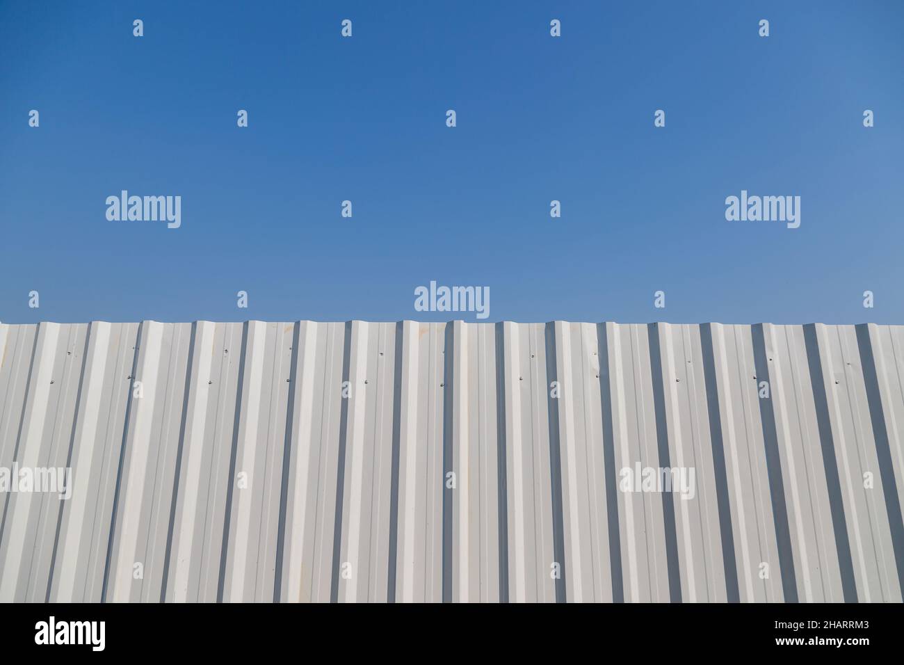 White corrugated metal fence with blue sky background Stock Photo - Alamy