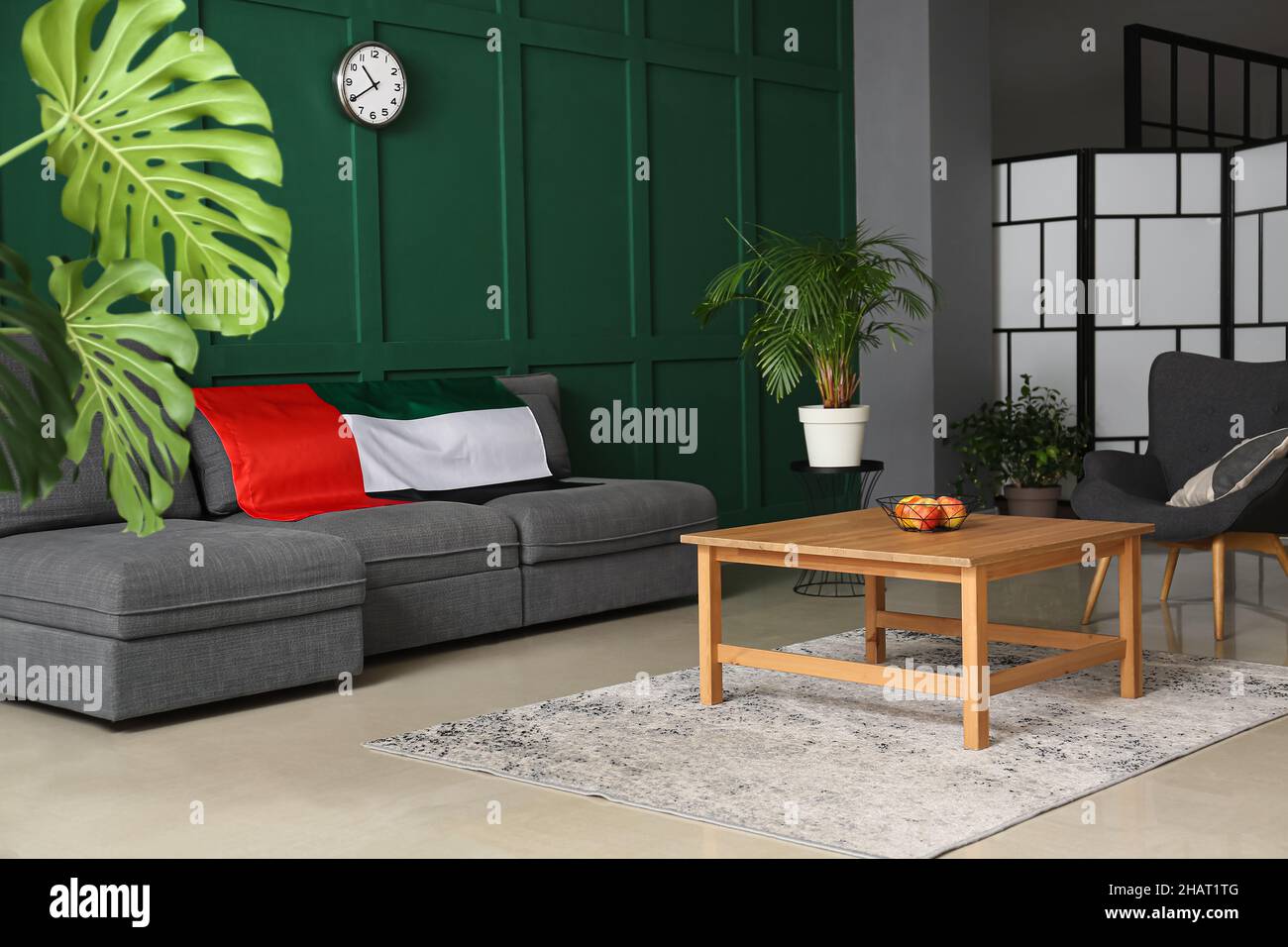 Interior of stylish living room with comfortable sofa and UAE flag near