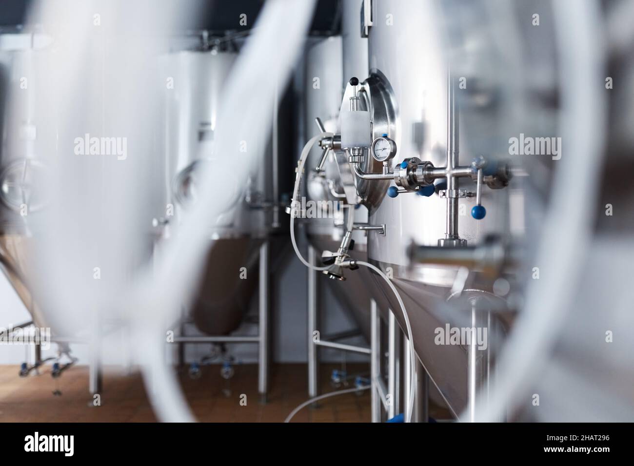 Equipment for the production of craft beer, containers for fermentation in the climatic chamber, pressure gauge with tubes and stainless steel tanks. Stock Photo