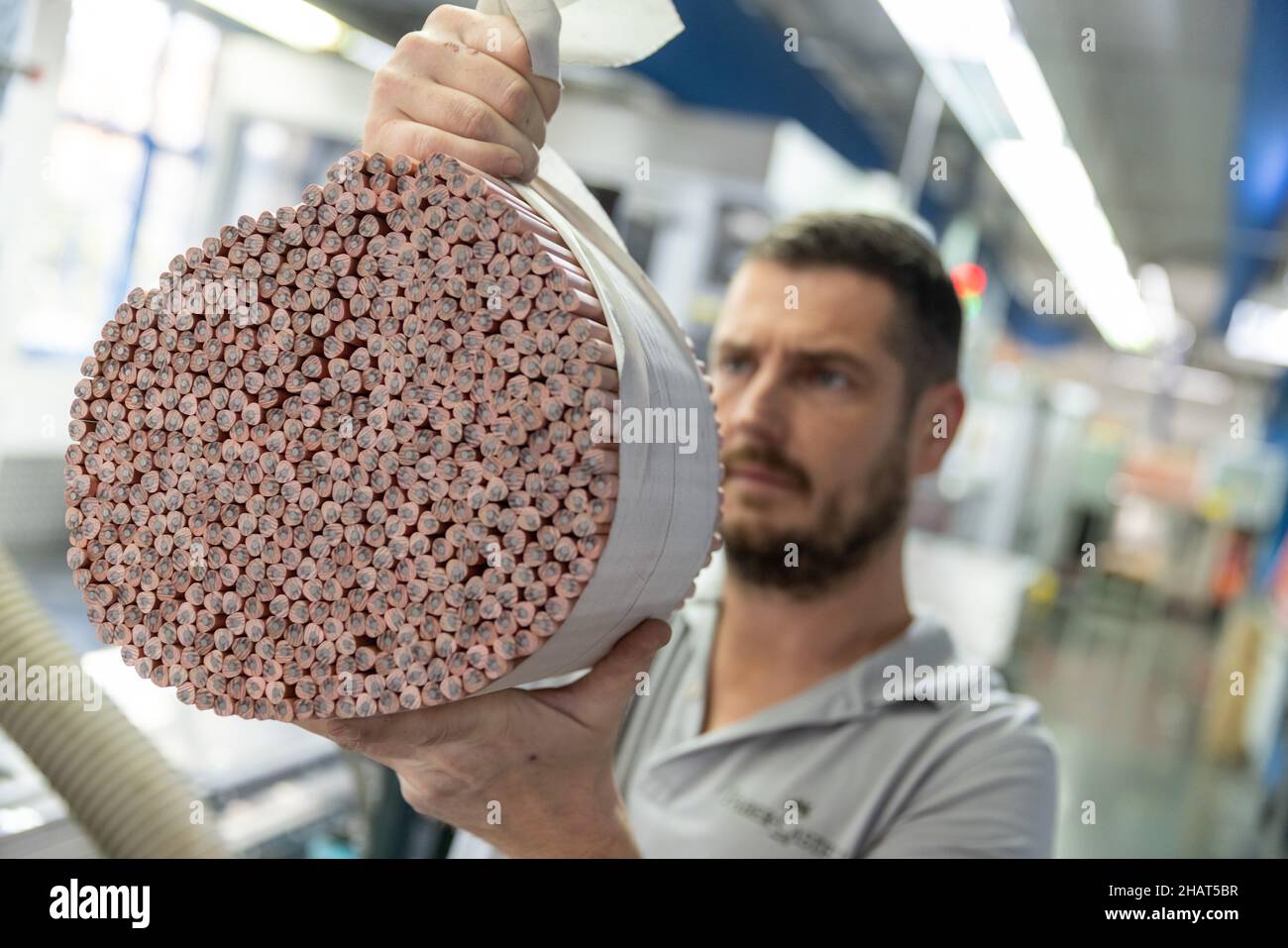 Stein, Germany. 24th Nov, 2021. An employee of the stationery manufacturer Faber-Castell visually inspecting raw pencils in the company's production facility. Credit: Daniel Karmann/dpa/Alamy Live News Stock Photo