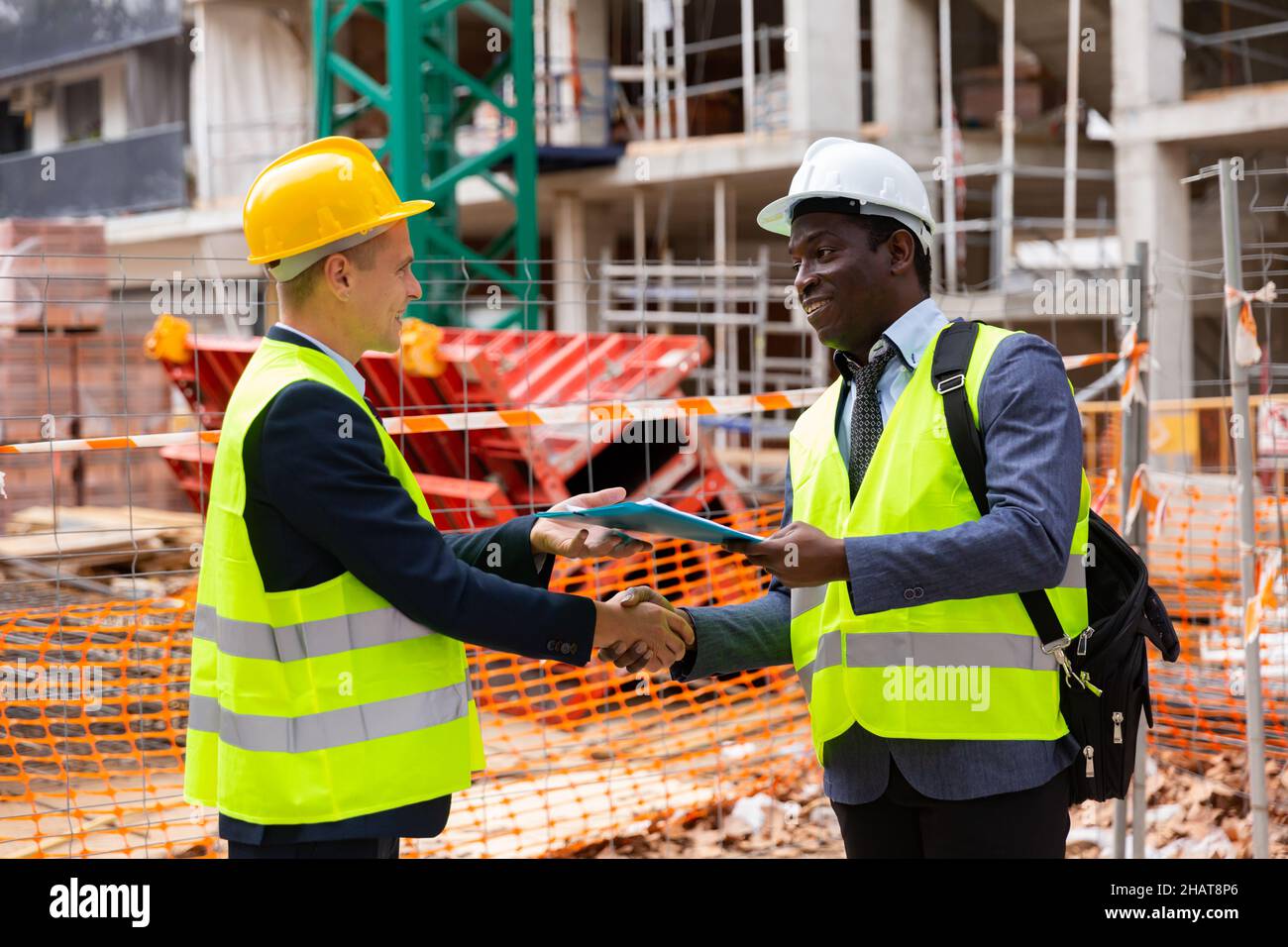 Two engineers concluding agreement and shaking hands Stock Photo