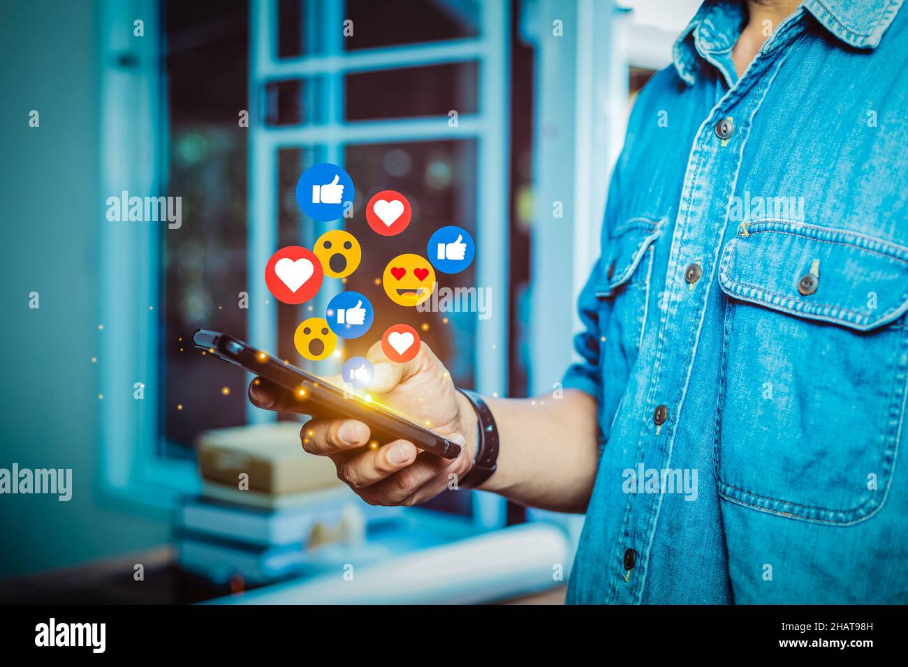 man standing on a mobile phone playing social media in the house Stock Photo