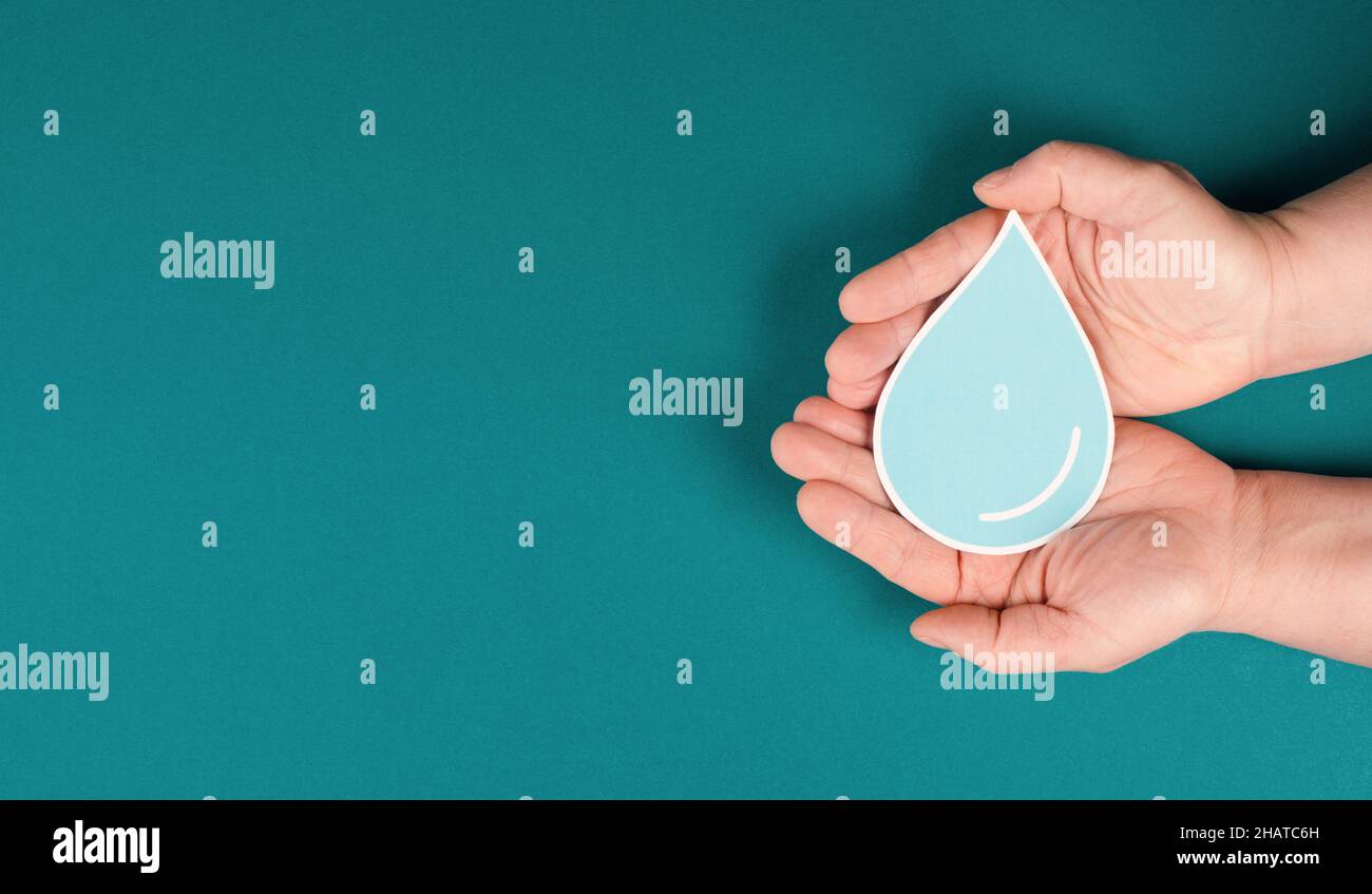 Hands holding a drop of water, paper cut out, environmental issue, copy space for text Stock Photo