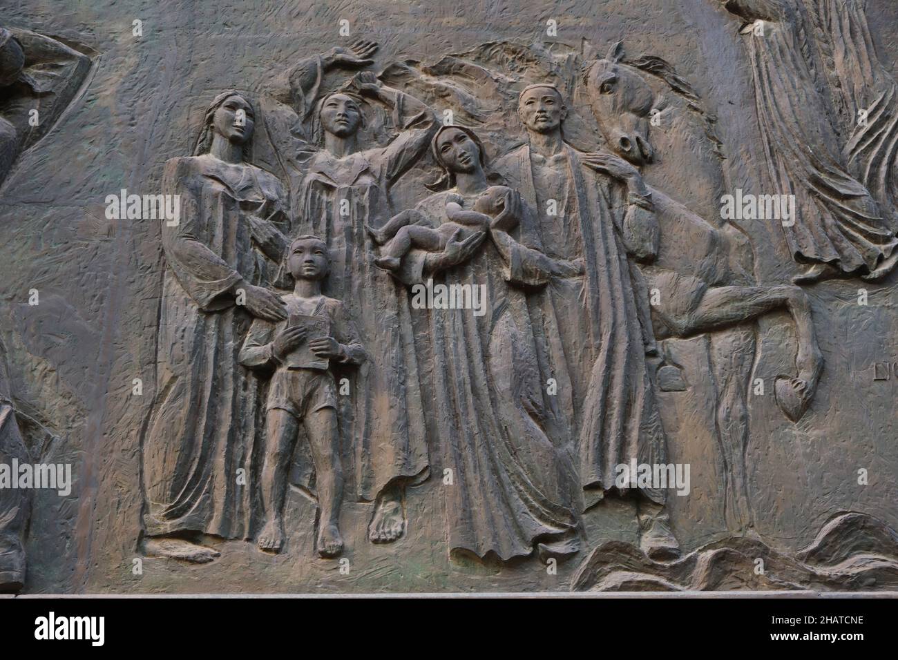 The bronze frieze Socialist artwork at the Mustakillik Maydoni metro, subway entrance. A family with baby and horse. In Tashkent, Uzbekistan. Stock Photo