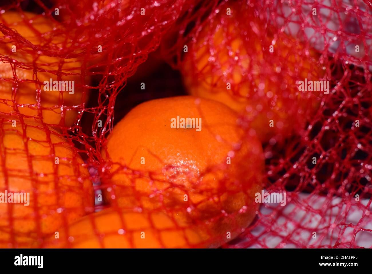 Mandarins in a red net as a close up Stock Photo