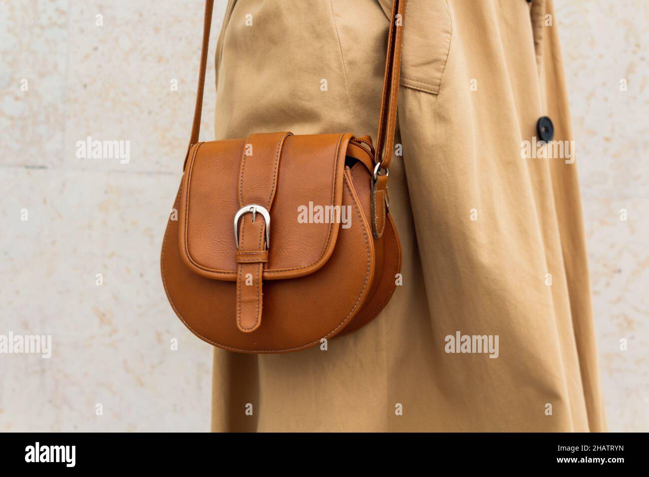 Beige small bag with long strap on woman. Stock Photo