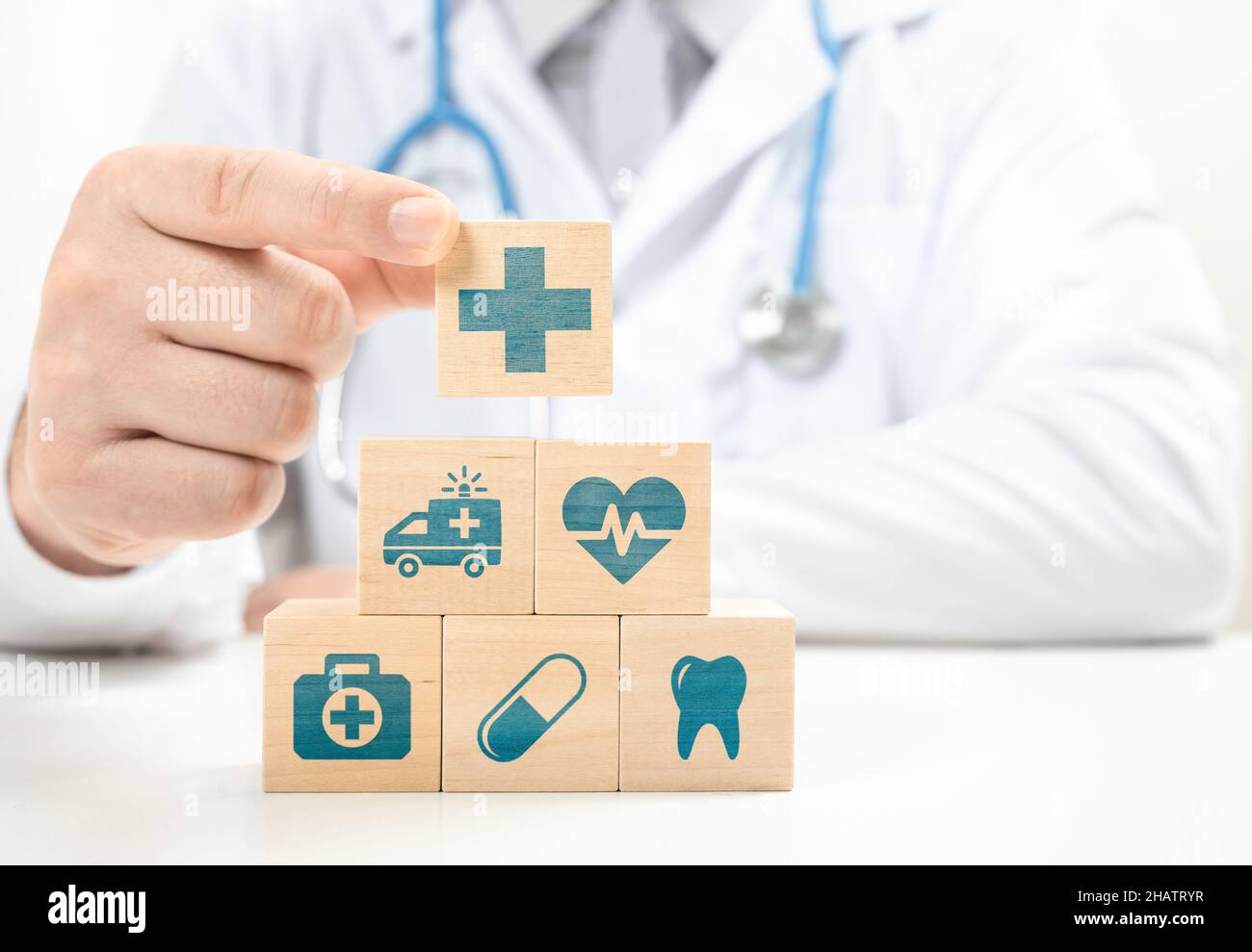 Healthcare and Insurance concept. Doctor hand choose cross sign on wood cube block. Health care insurance or service concept. Medical healthcare icons Stock Photo