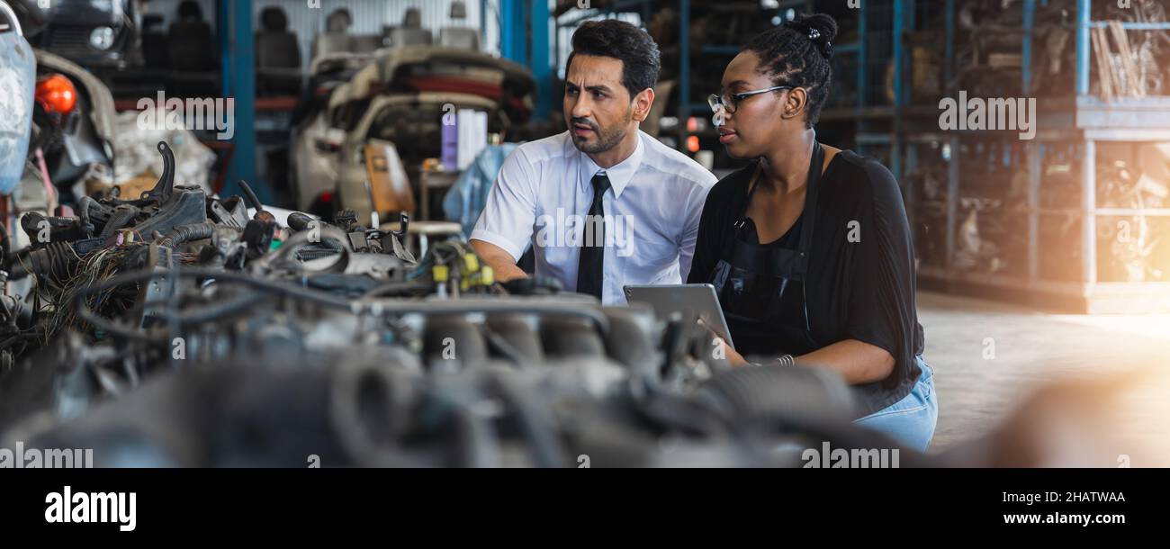 Old auto parts seller check on laptop and explain to customer or boss