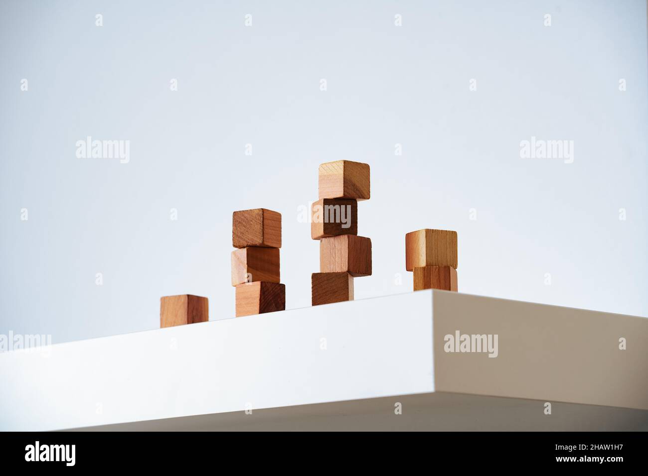 Wooden cedar cubes on white podium and background. Modern minimalism, climbing ladder and organic self-improvement, accepting a multi-faceted personal Stock Photo