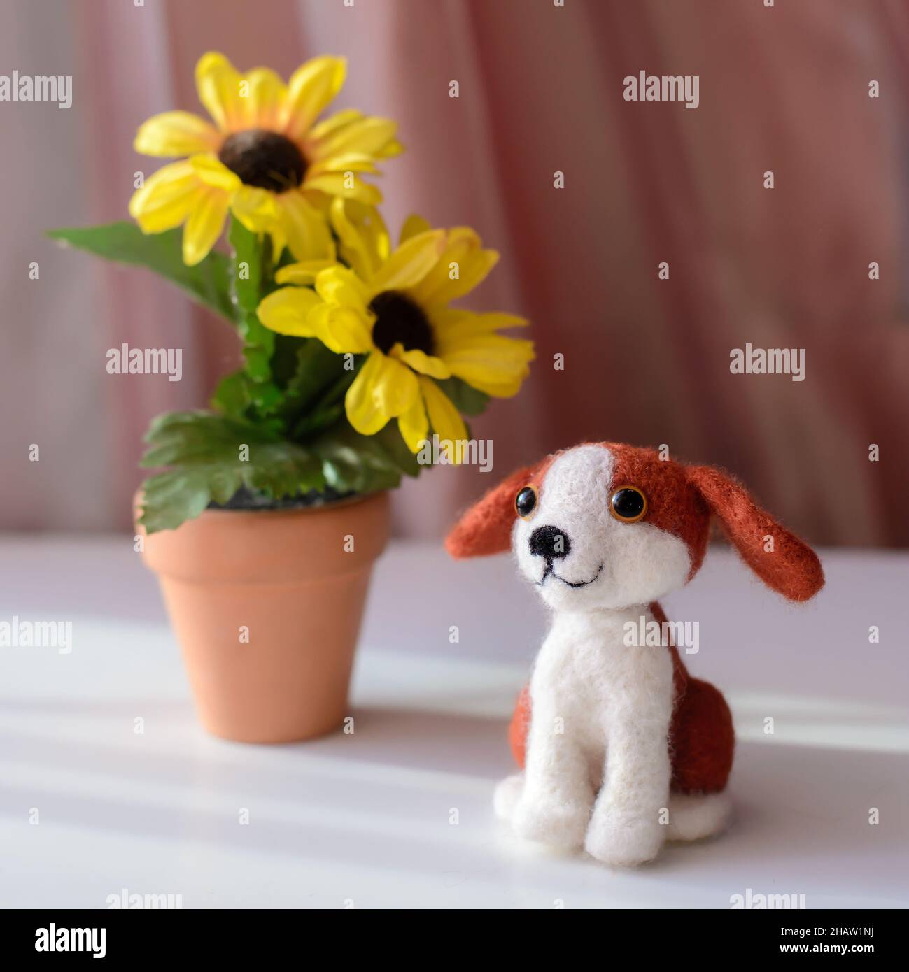 https://c8.alamy.com/comp/2HAW1NJ/cute-woolly-toy-dog-under-green-leaves-on-a-sunny-day-felting-wool-2HAW1NJ.jpg