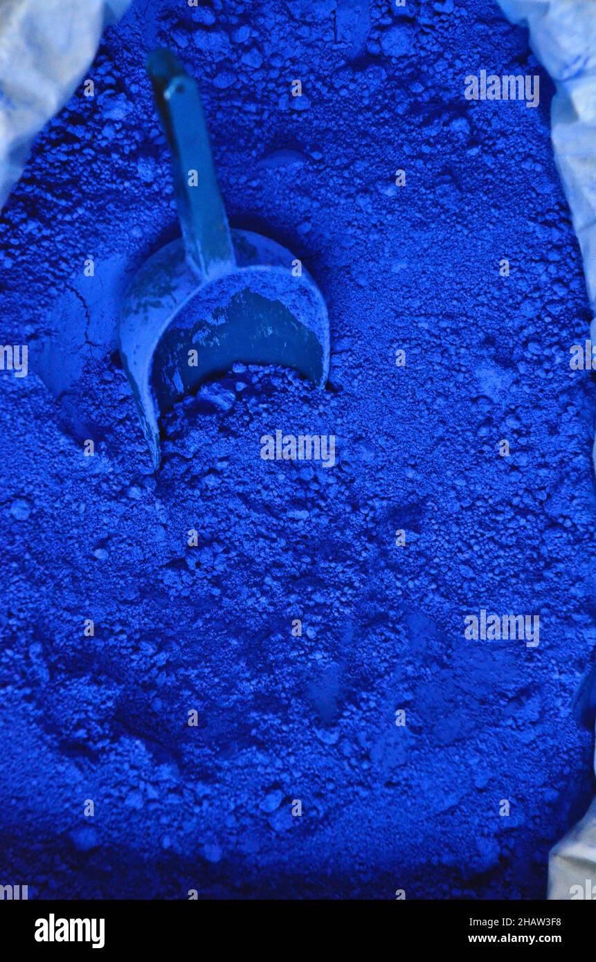 Grinding blue paint pigments using a glass muller Stock Photo - Alamy