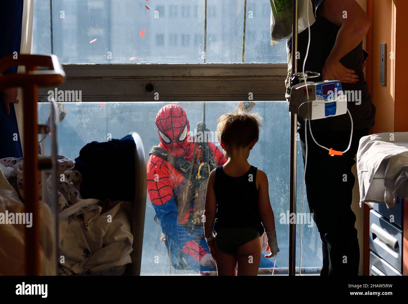 A man dressed as a Spiderman jokes with a child hospitalised in the paediatrics ward of the San Paolo hospital, in Milan, Italy, December 15, 2021. REUTERS/Flavio Lo Scalzo Stock Photo